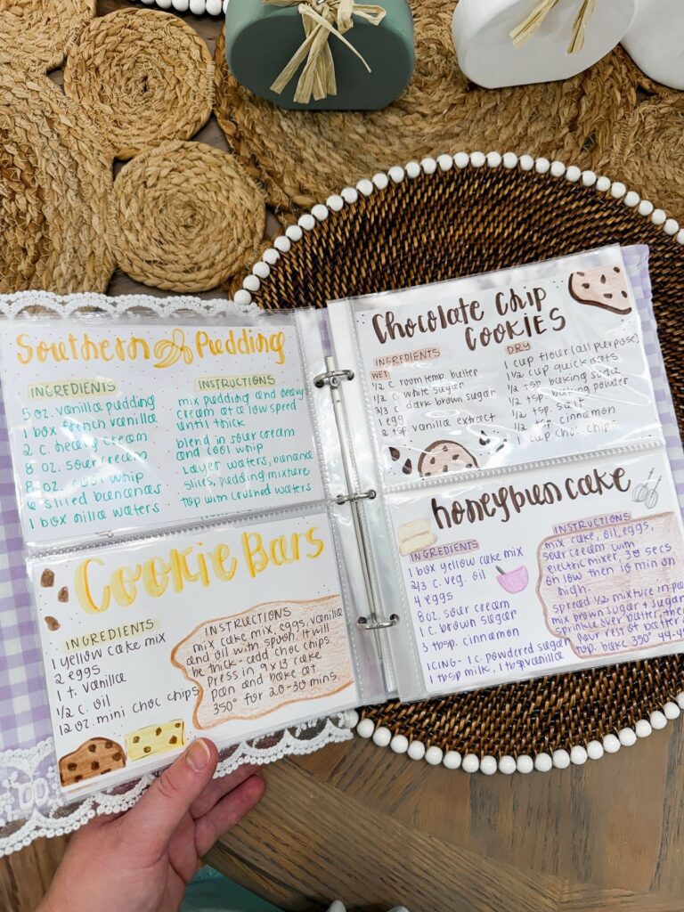 Open binder with handwritten recipe cards resting on a woven beaded tray.