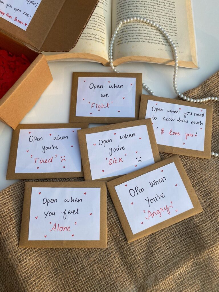 Handwritten open when letters in brown envelopes on burlap with a pearl necklace