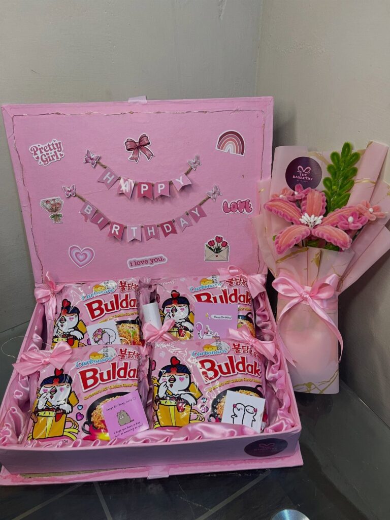 Pink birthday gift box filled with Buldak ramen packages and a matching flower bouquet.