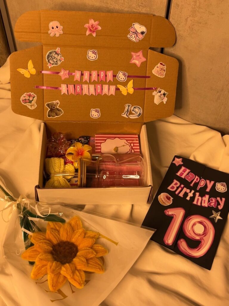 Custom birthday gift box with stickers, a birthday card, and a crochet sunflower.