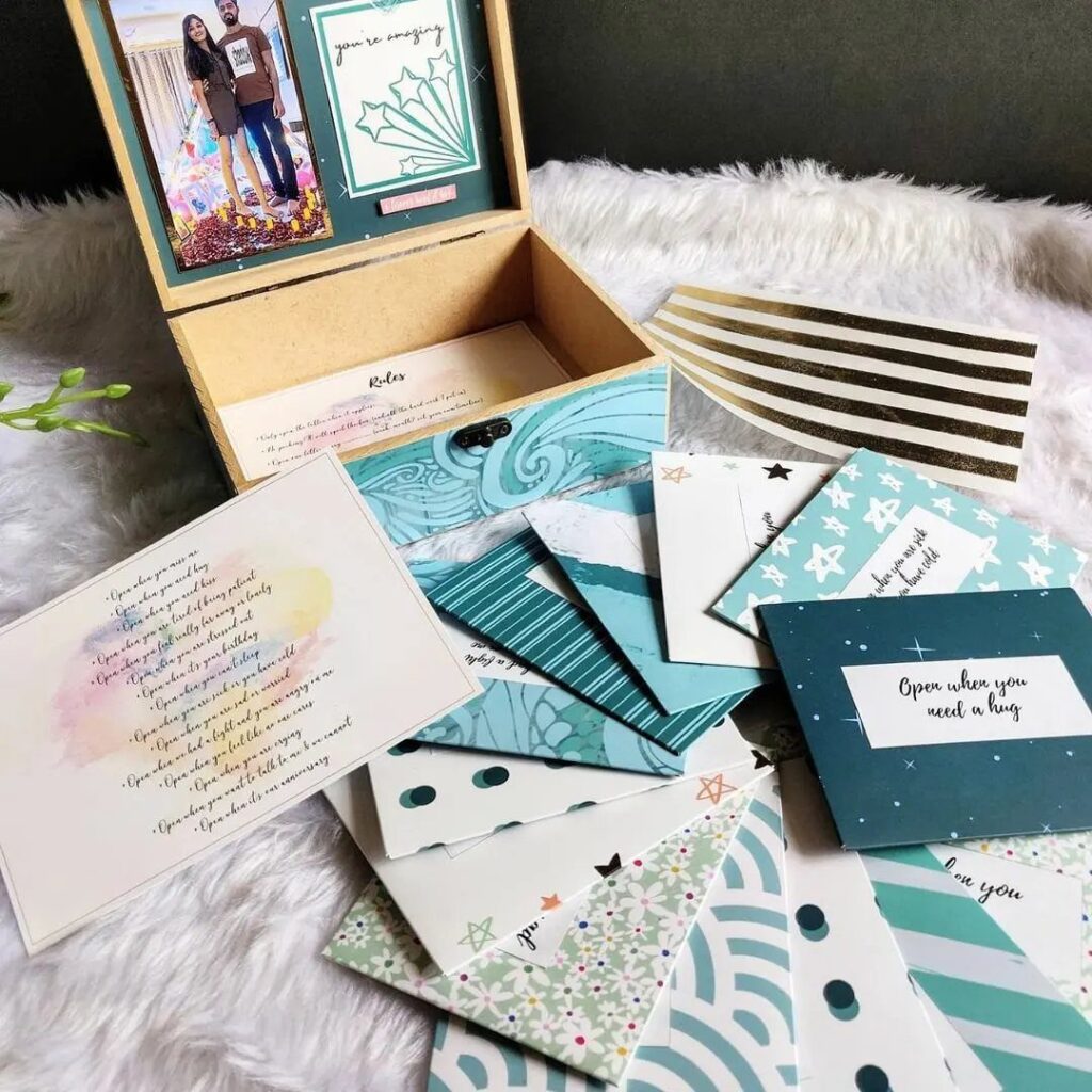 Blue and teal stationery set with handwritten letters and a couple's photo box.