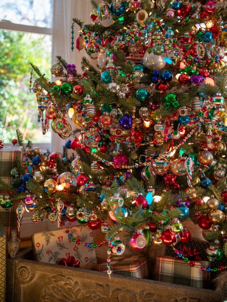 Decorated Christmas tree with colorful ornaments and wrapped gifts at the base