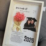 Graduation keepsake shadow box with photo of friends, pink flowers, and Class of 2026