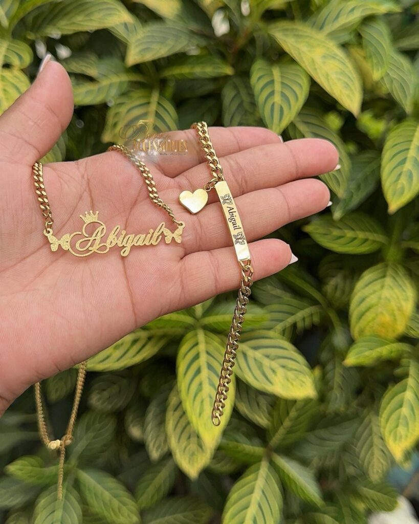 Gold personalized necklaces with the name Abigail held in a person's open hand.