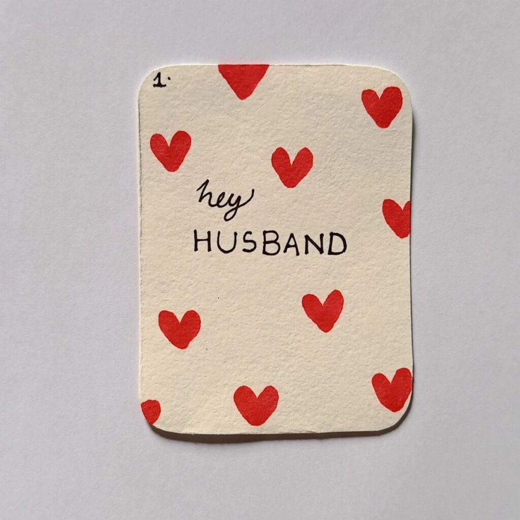 Handmade Valentine card with red hearts and the words hey HUSBAND written on it.
